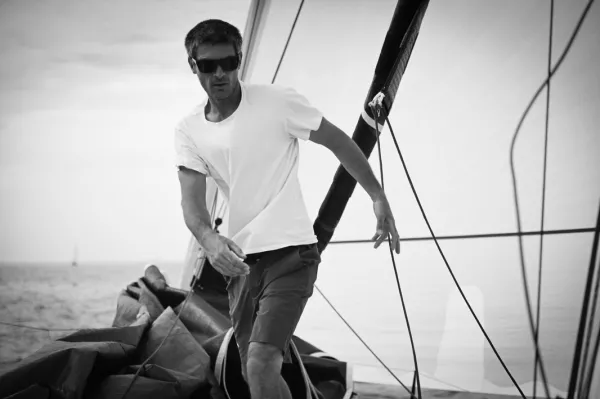 Peut être une image en noir et blanc de course de bateaux, voile, voilier, yacht et texte.