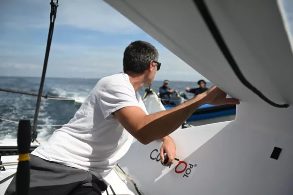Peut être une image de course de bateaux, voilier, voile, yacht et texte.